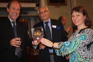 George Grishin receives Russian Insurance Club memento from Vasilina Bindley. Centre is Len van der Put.