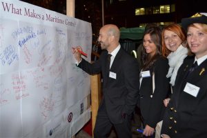 Phil Parry signs the board of "What Makes a Maritime centre?" in the presence of many female members and guests...