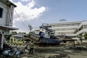 2004: A scene of devastation in front of Hotel Medan in Aceh City centre. The force of the tsunami swept fishing boats like this one hundreds of metres inland, crashing into the city and destroying anything along the way. WFP/Rein Skullerud