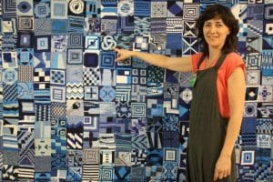 Alejandra Corral (Kuska) with Black Tears Project tapestry.