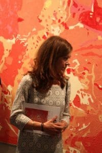 Victoria Hislop with the oil painting I Love You in background.