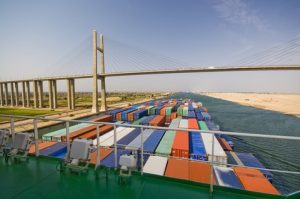 A container ship passes under the Suez Canal Bridge. Panalpina is set to acquire its Egyptian agent Afifi, a family-owned company specializing in freight forwarding, customs clearance and logistics