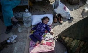 A child sleeps outside the screening centre at Moria on Lesvos. Refugees and migrants live in tents outside the screening centre here until there is a space available to accommodate them inside. Photo: UNHCR/S. Baltagiannis