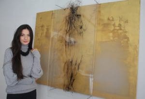 Alina Teodorescu with her mixed media work A Personal Journey of Faith and Doubt.