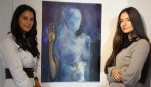 Michaela Vergottis (left) and Alina Teodorescu with Alina’s oil on canvas Empatic Existence.
