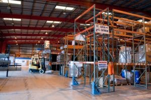 An employee moves pallet of dry goods at the warehouse with a forklift.